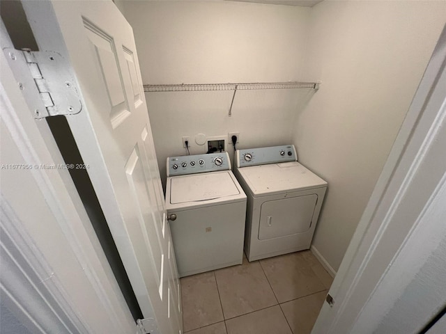 clothes washing area featuring light tile patterned floors and separate washer and dryer