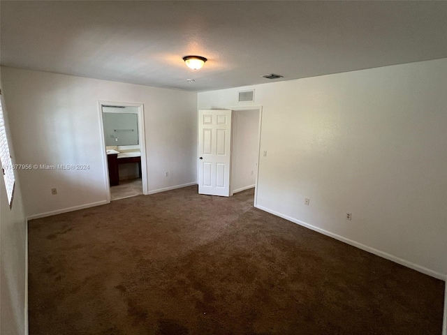 empty room featuring dark carpet