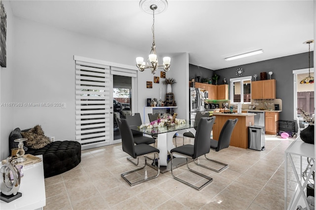 dining area with light tile patterned flooring and a chandelier