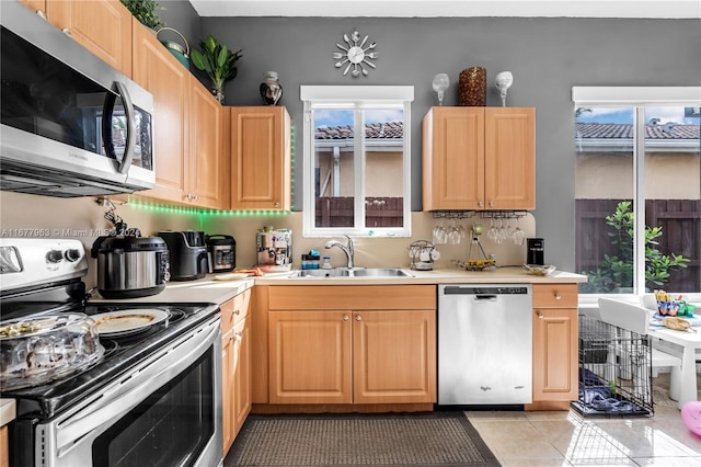 kitchen featuring appliances with stainless steel finishes, light brown cabinets, sink, and light tile patterned floors