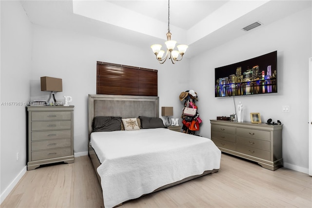 bedroom featuring a chandelier and light wood-type flooring