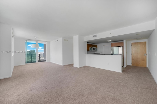 unfurnished living room featuring light colored carpet