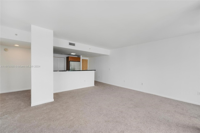 unfurnished living room with light carpet