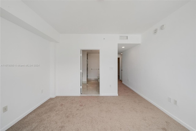 spare room featuring light colored carpet