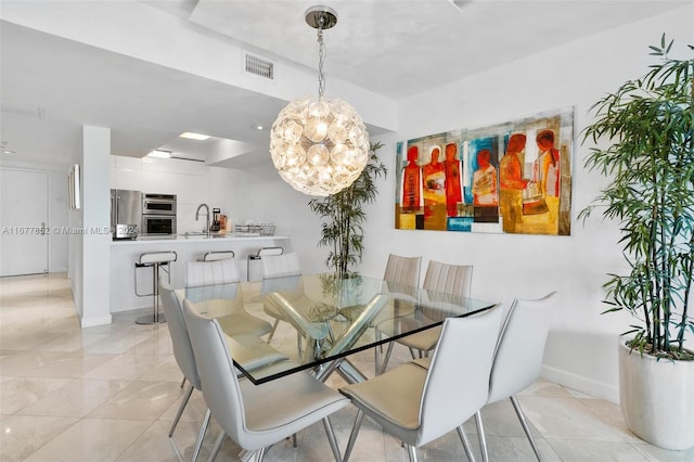 tiled dining room with a chandelier