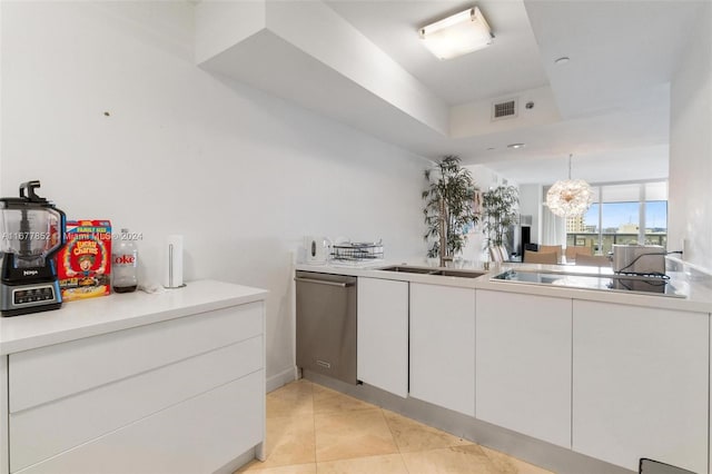 kitchen featuring sink, black electric cooktop, stainless steel dishwasher, white cabinets, and a notable chandelier