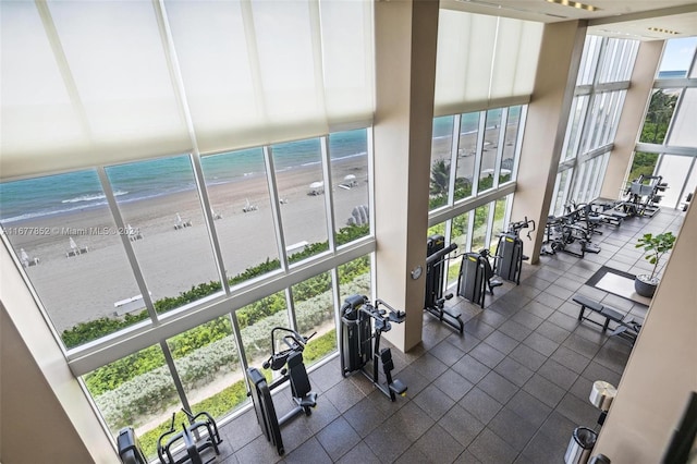 gym featuring a water view and a beach view