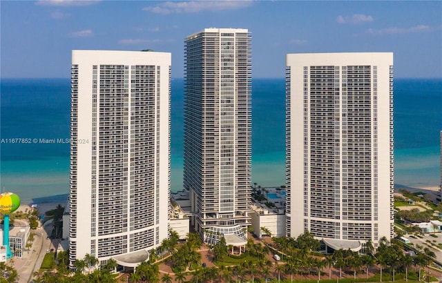 view of building exterior featuring a water view and a view of the beach