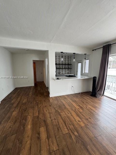 unfurnished living room with hardwood / wood-style floors and a textured ceiling