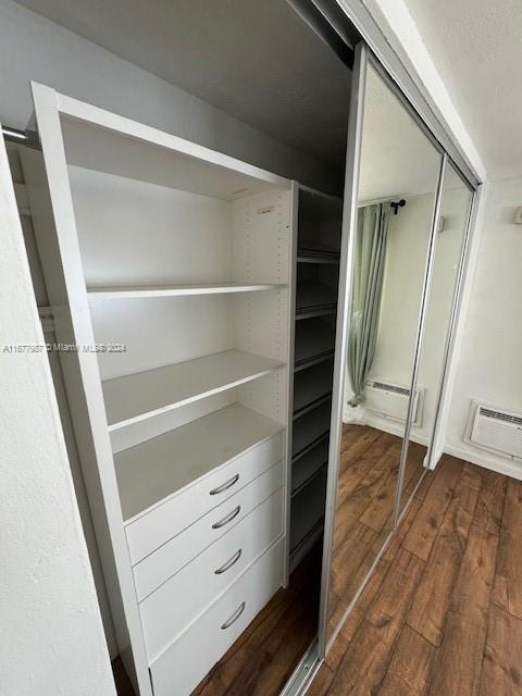 closet featuring a baseboard heating unit and a wall unit AC