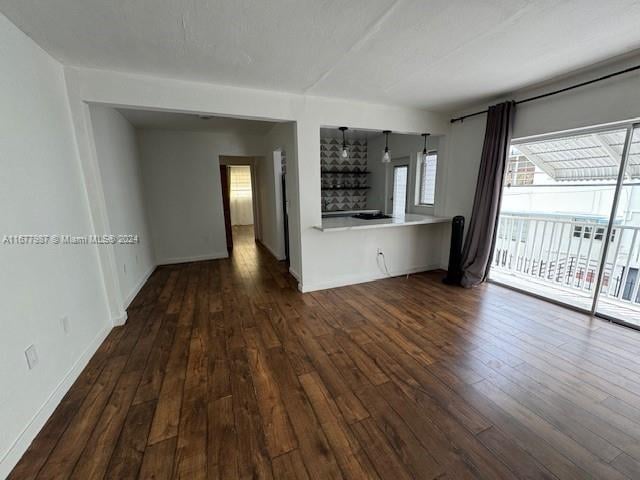 unfurnished living room featuring dark wood-type flooring