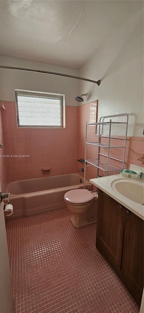 full bathroom with vanity, tiled shower / bath combo, toilet, and tile patterned flooring