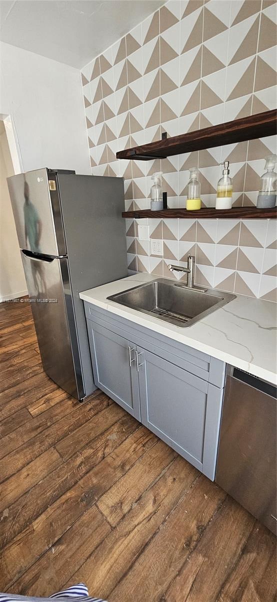 kitchen featuring dark hardwood / wood-style floors, sink, backsplash, and gray cabinetry