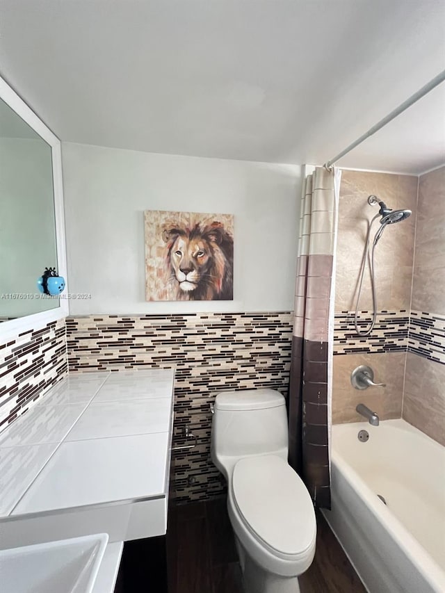 bathroom with shower / bath combo with shower curtain, toilet, and tile walls