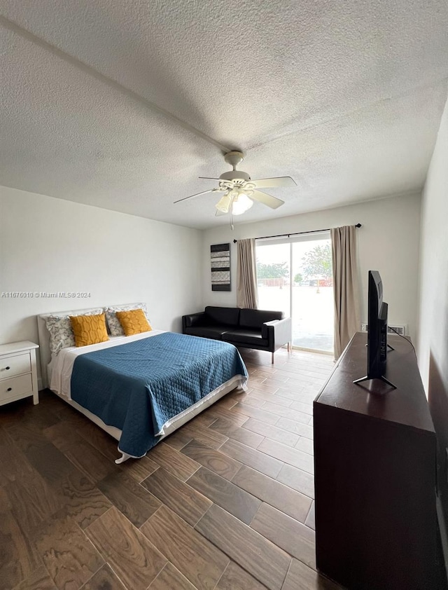 bedroom with access to outside, ceiling fan, wood-type flooring, and a textured ceiling