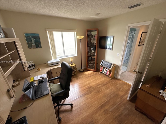 home office featuring hardwood / wood-style floors and a textured ceiling