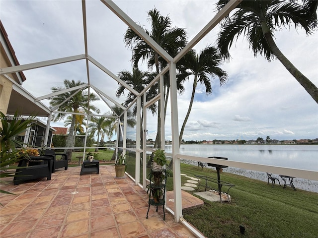 view of patio with a water view and glass enclosure