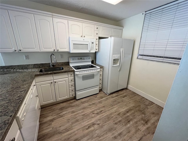 kitchen with white appliances, light hardwood / wood-style floors, white cabinetry, and sink