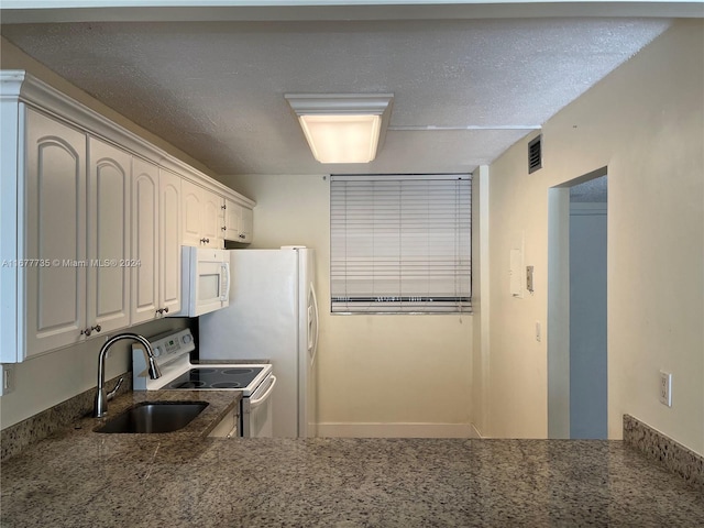 kitchen with a textured ceiling, white cabinets, sink, and white appliances