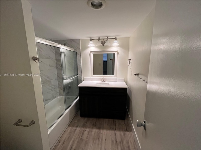 bathroom with vanity, enclosed tub / shower combo, and hardwood / wood-style flooring