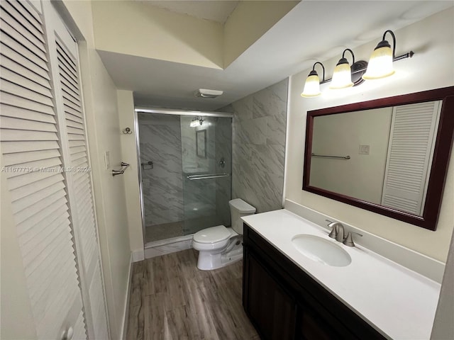 bathroom with vanity, toilet, an enclosed shower, and hardwood / wood-style floors