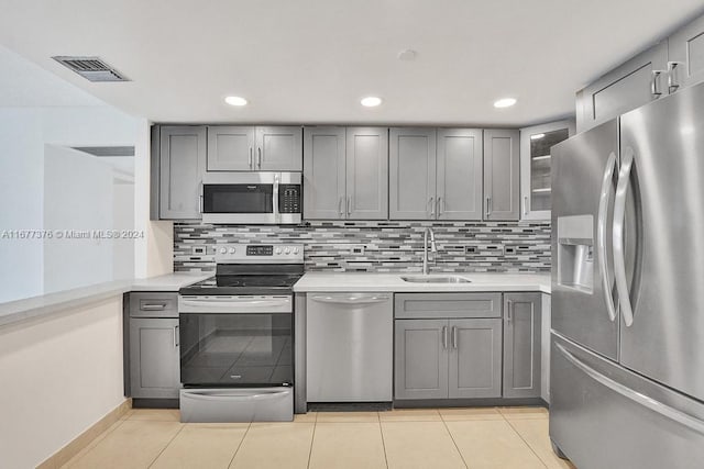 kitchen featuring gray cabinets, sink, appliances with stainless steel finishes, and tasteful backsplash