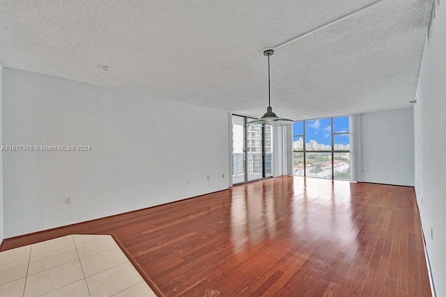 interior space featuring light hardwood / wood-style flooring, a textured ceiling, and floor to ceiling windows