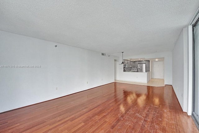 interior space featuring a textured ceiling and light wood-type flooring