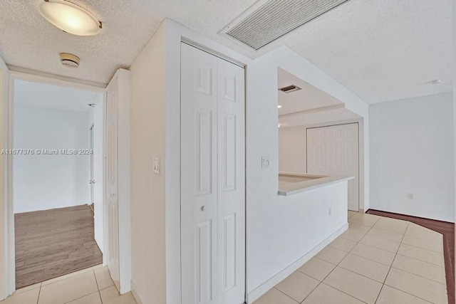 hallway featuring a textured ceiling and light wood-type flooring