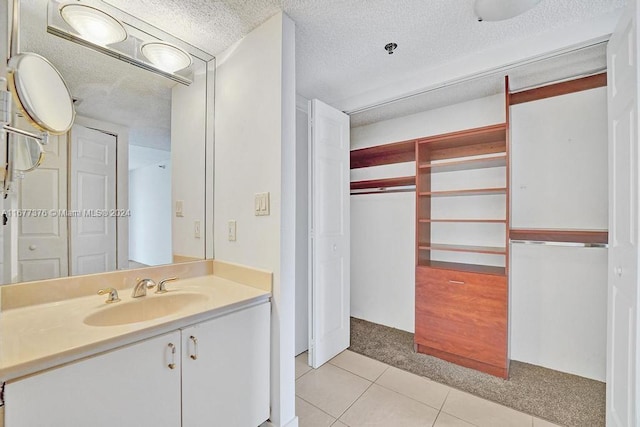 bathroom with vanity, a textured ceiling, and tile patterned floors