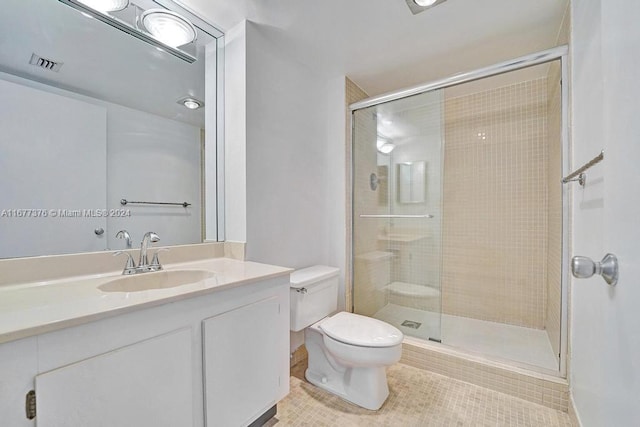 bathroom featuring vanity, toilet, tile patterned floors, and a shower with door