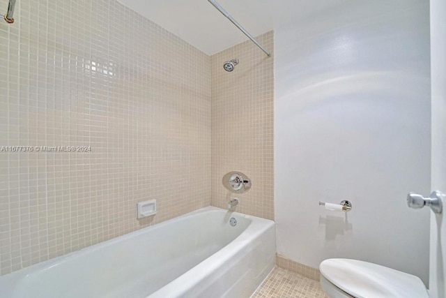 bathroom featuring toilet, tile patterned flooring, and tiled shower / bath