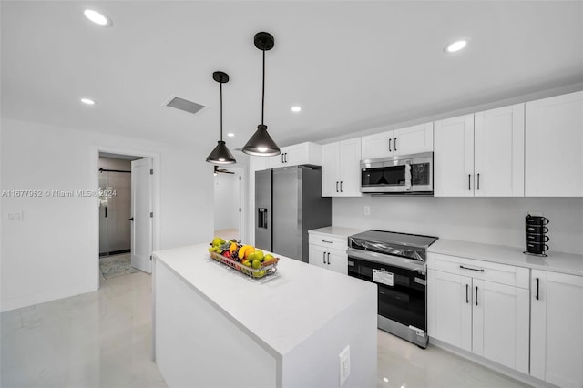 kitchen with decorative light fixtures, a kitchen island, white cabinetry, and appliances with stainless steel finishes