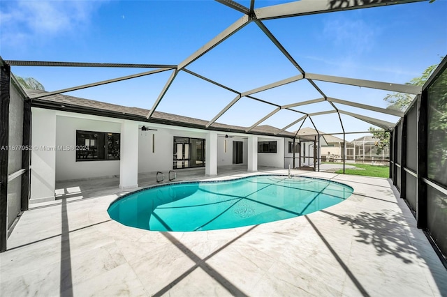 view of swimming pool featuring ceiling fan, a patio area, and a lanai