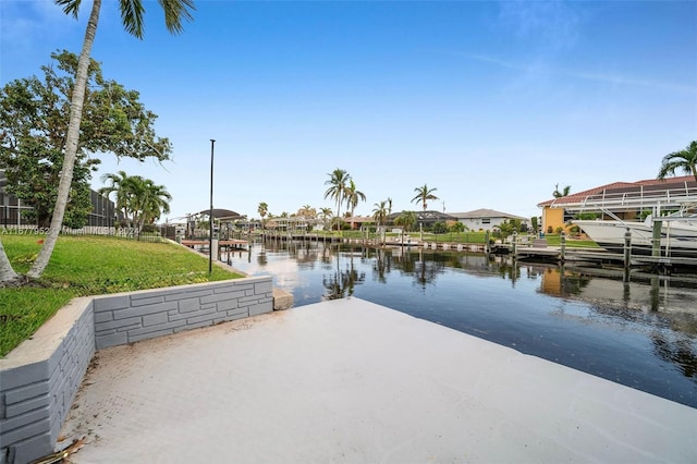 dock area with a lawn and a water view