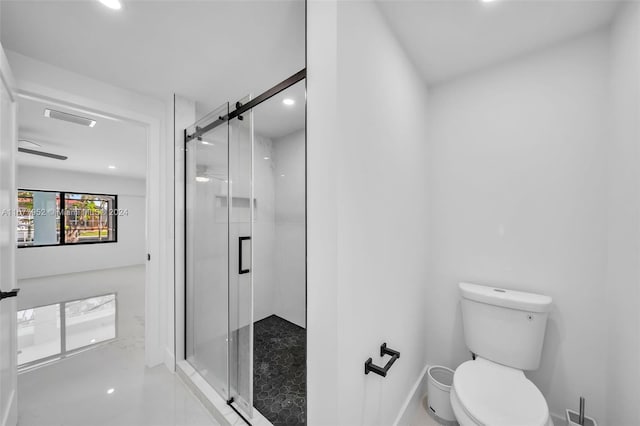 bathroom with tile patterned floors, toilet, and a shower with door