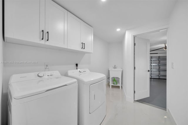 laundry room with washing machine and clothes dryer, sink, and cabinets