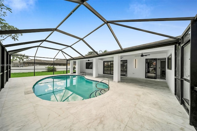 view of pool with ceiling fan, a patio area, and glass enclosure