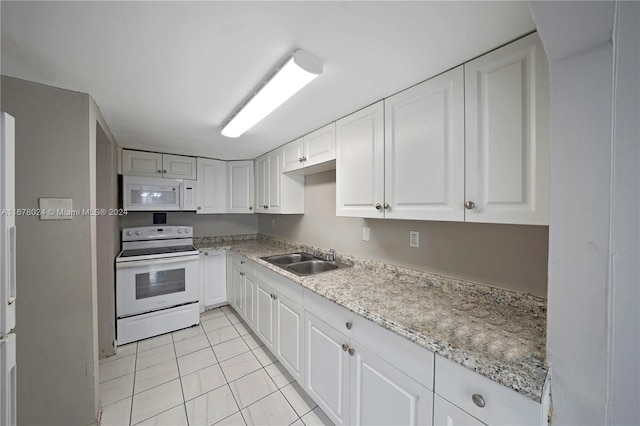 kitchen with white cabinets, light tile patterned floors, light stone countertops, sink, and white appliances