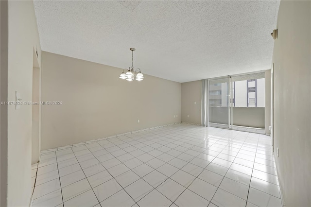 unfurnished room featuring a textured ceiling, light tile patterned floors, and a chandelier