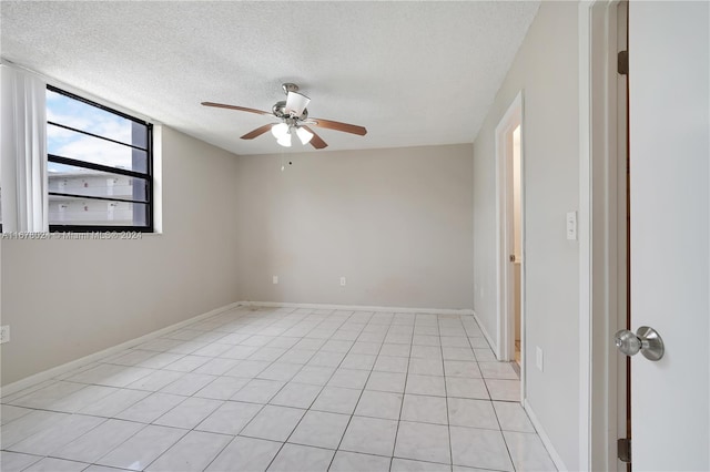 tiled spare room featuring a textured ceiling and ceiling fan