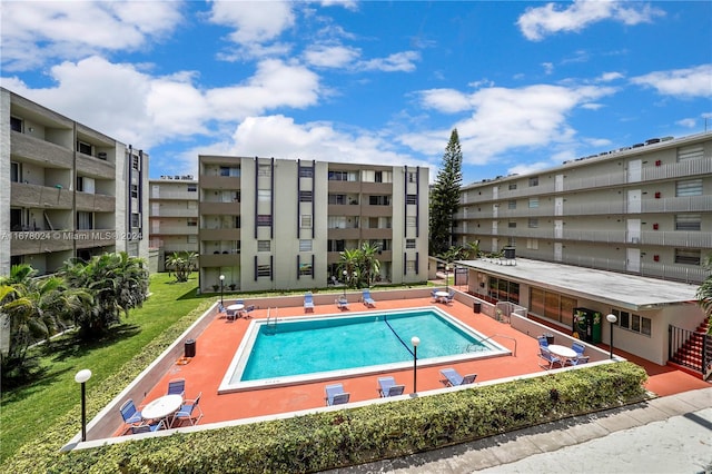 view of pool with a patio and a lawn