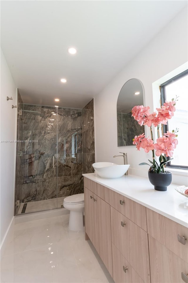 bathroom featuring an enclosed shower, vanity, and toilet