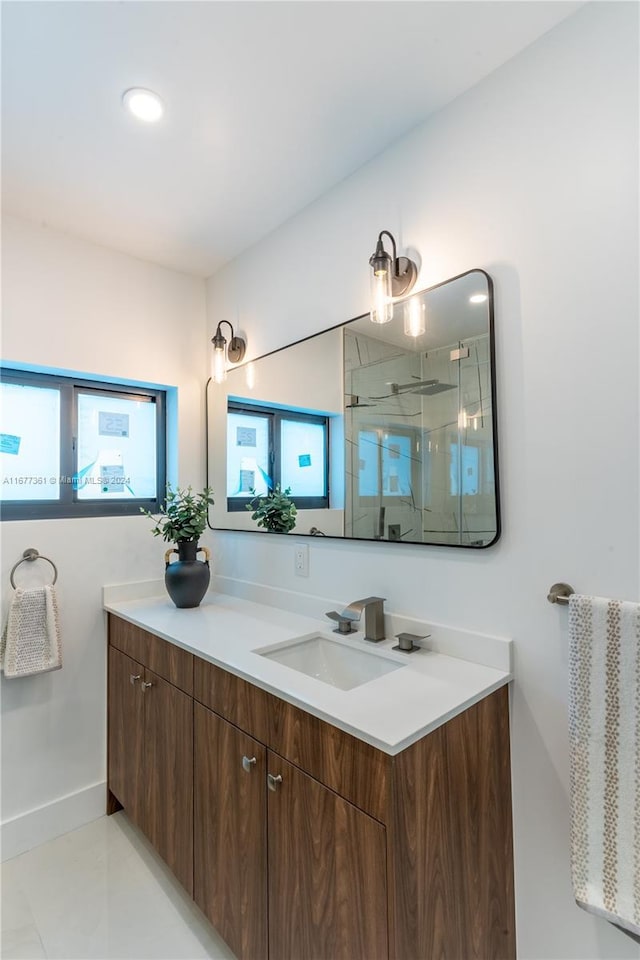 bathroom featuring tile patterned flooring, vanity, and an enclosed shower