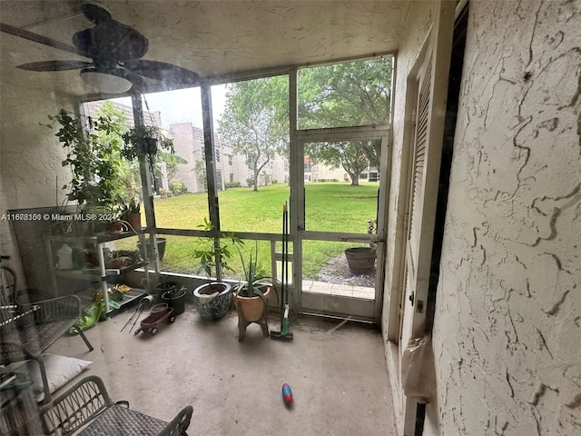 unfurnished sunroom with ceiling fan