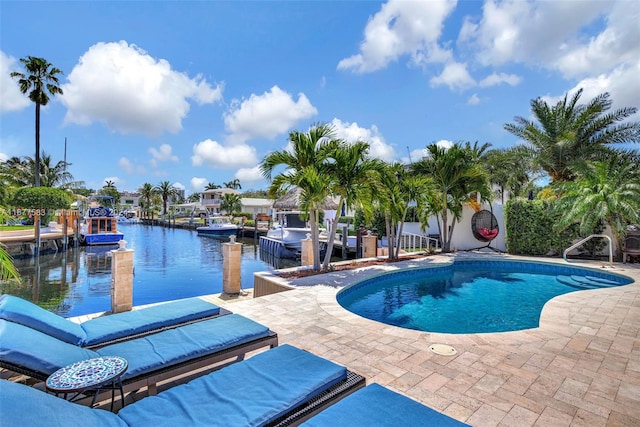 view of swimming pool with a patio area, a water view, and a boat dock