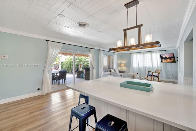 kitchen featuring a breakfast bar, crown molding, and light hardwood / wood-style floors