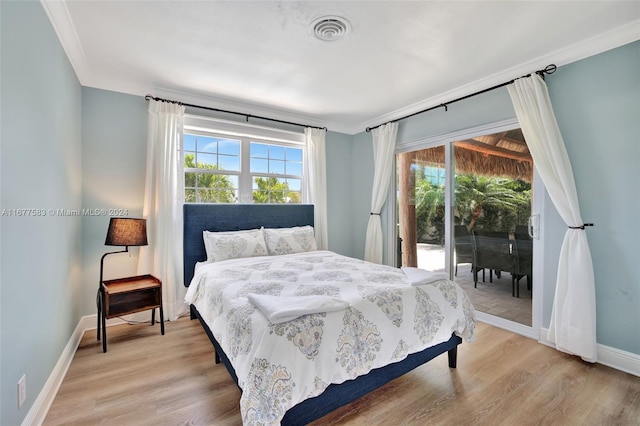 bedroom featuring light hardwood / wood-style floors, multiple windows, and access to outside