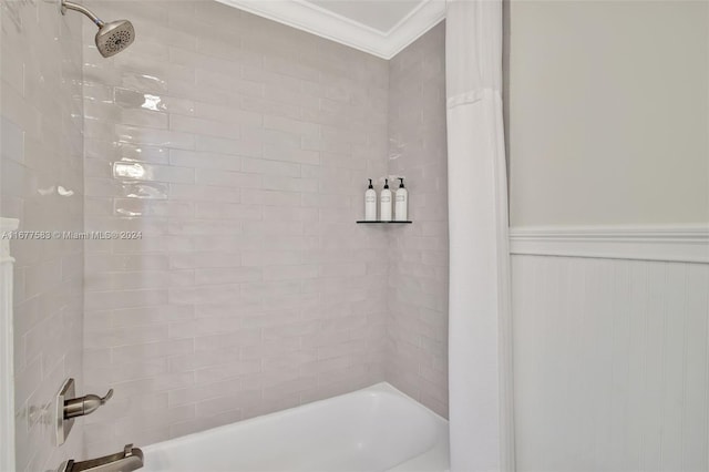 bathroom with ornamental molding and tiled shower / bath