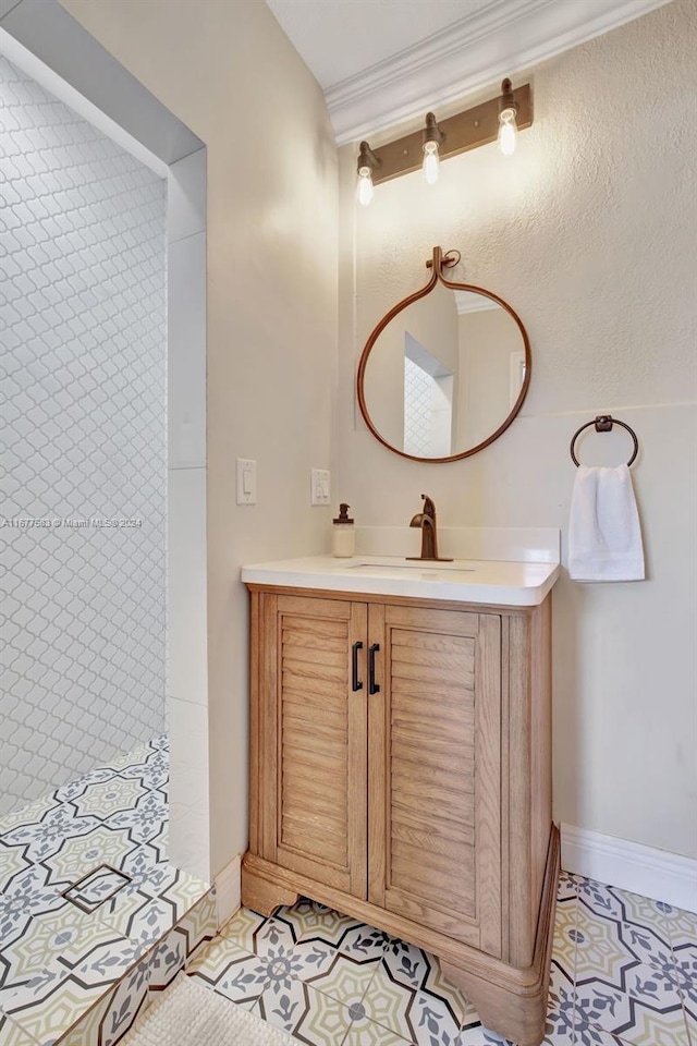 bathroom with vanity, ornamental molding, a tile shower, and tile patterned flooring